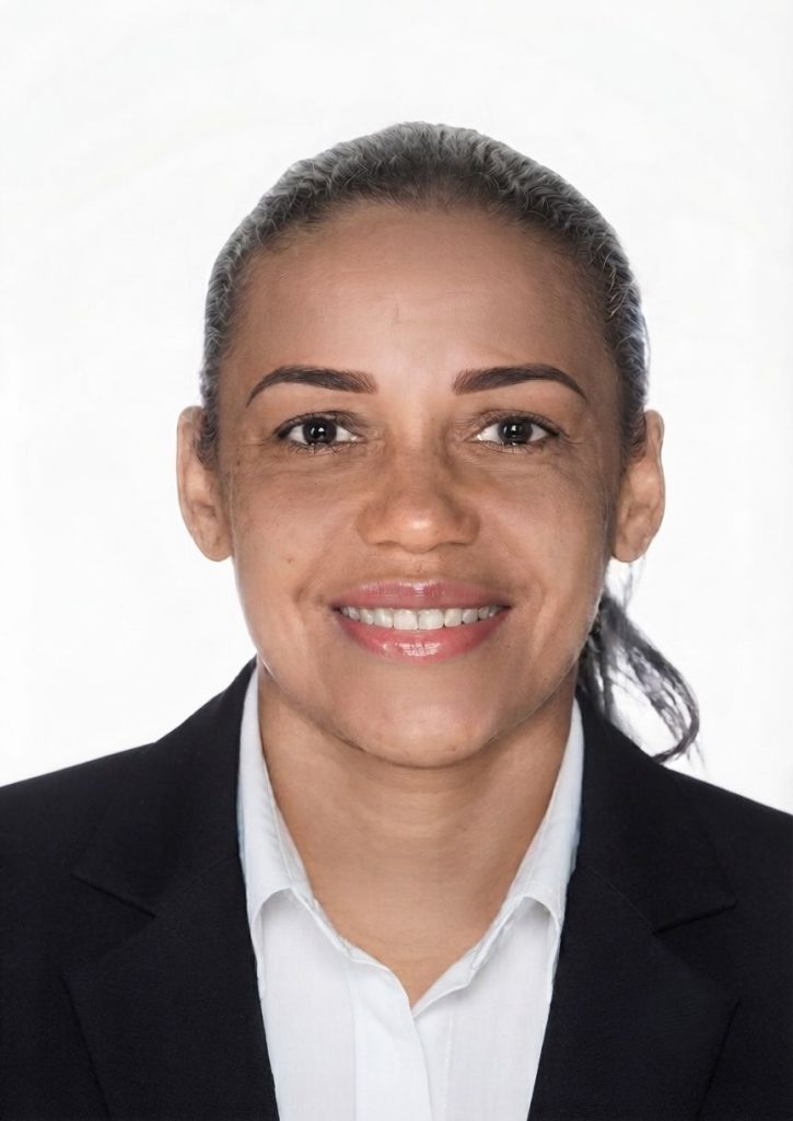 Foto de urna de Jack Lopes, candidata a deputada federal pelo Partido Verde no Espírito Santo, mulher sorridente com cabelo preso, vestindo blazer preto e camisa branca